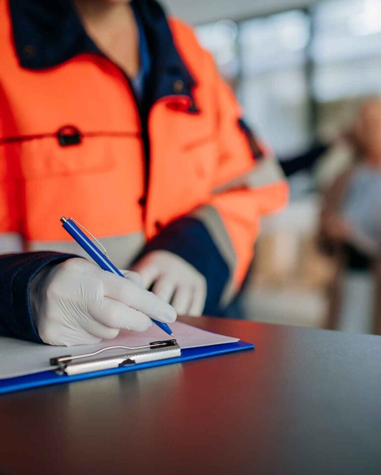 Profissional preenchendo a documentação de segurança do trabalho em prancheta
